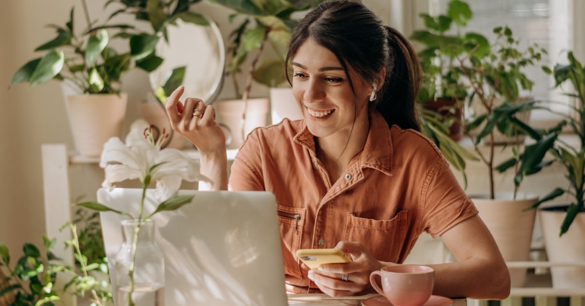 Travel advisor smiling at her laptop in a bright home office