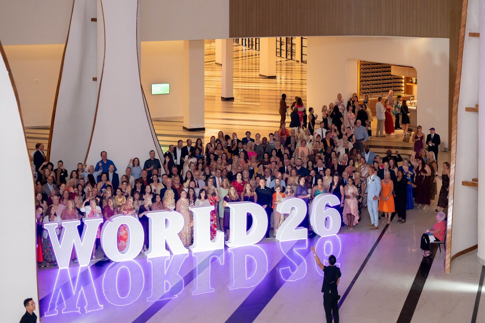 Hundreds of advisors gathered behind the WORLD26 sign
